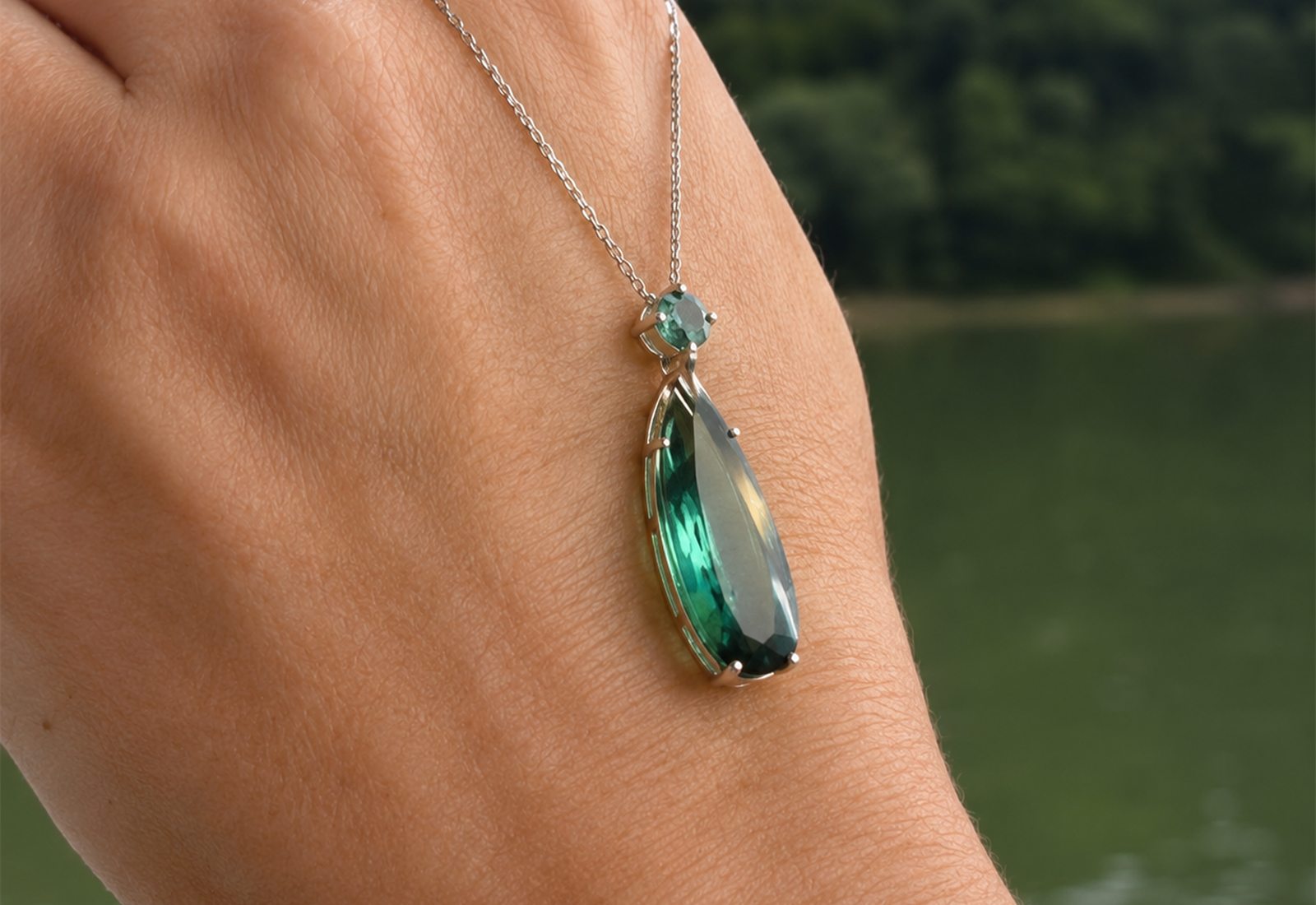 Green tourmaline drop pendant worn over a hand