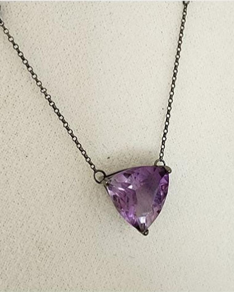 Trillion-cut amethyst pendant on a darkened fine chain