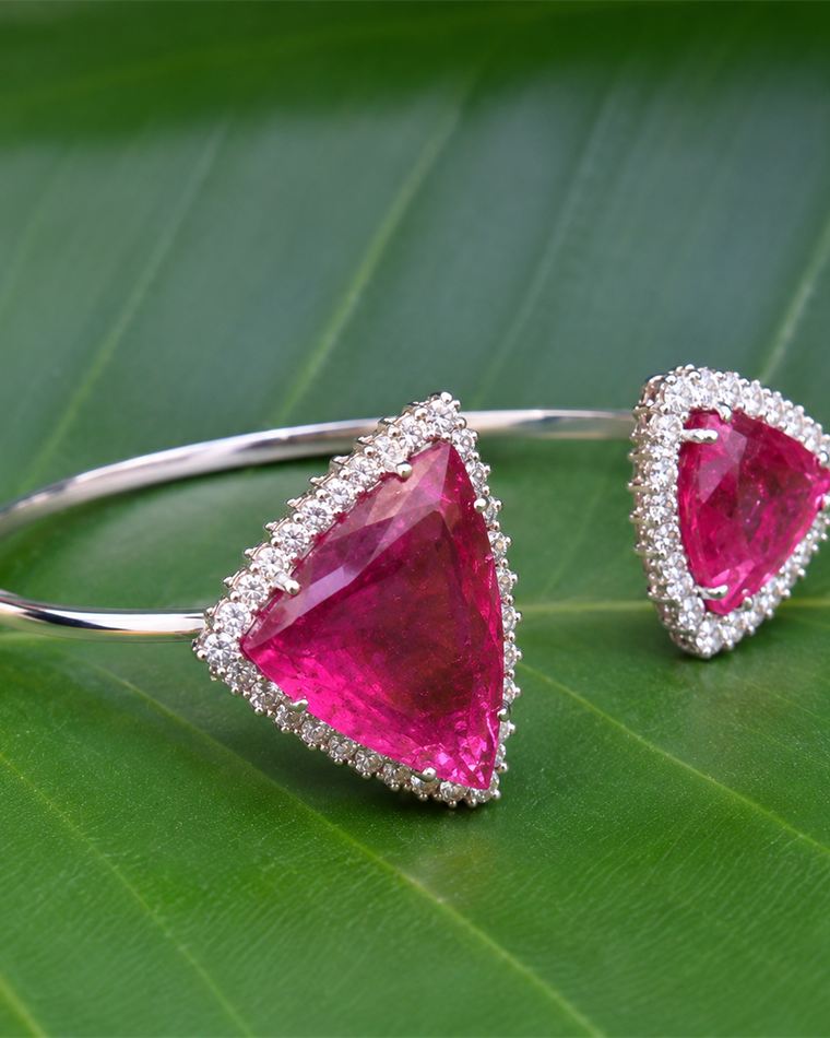 Open white gold bangle with a trillion-cut rubellite in a diamond halo, shown with the matching ring